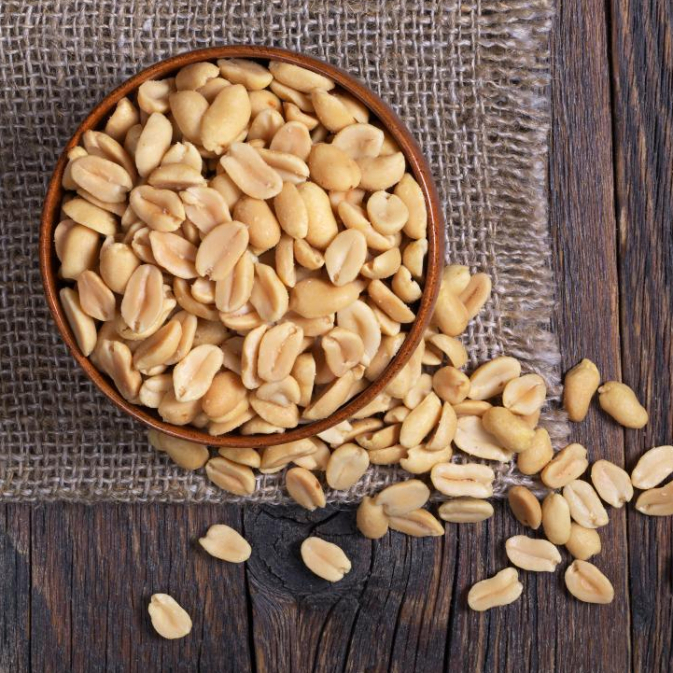 peanuts-in-a-bowl-on-wooden-table-top-down-view